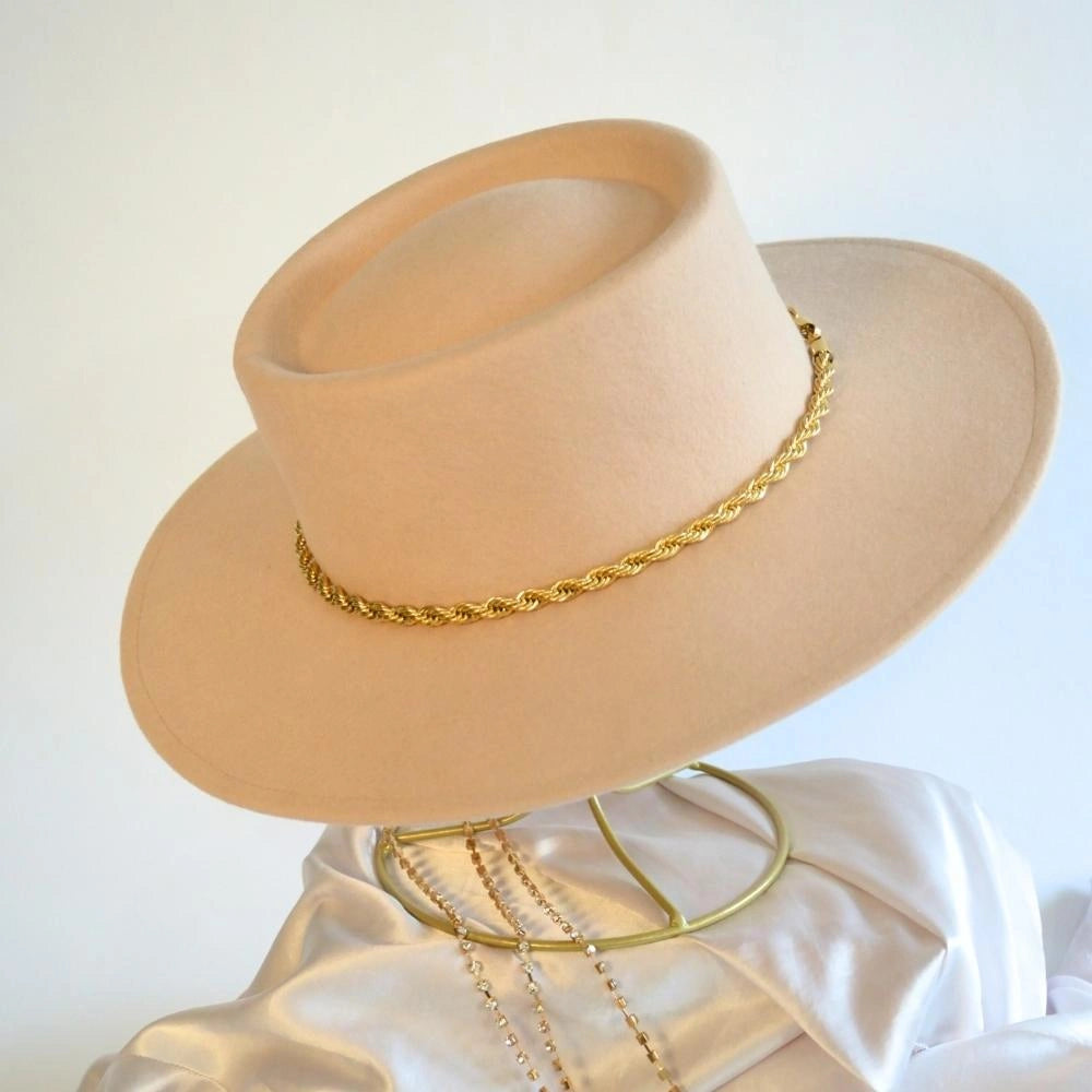 A side view of the wool beige boater hat with the 18k gold twist hat band.