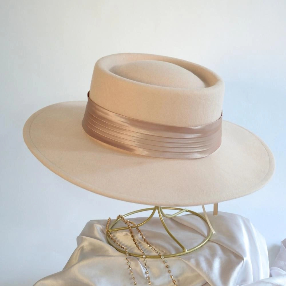 A back view of the beige beauty wool satin lined boater hat with the caramel satin hat band.