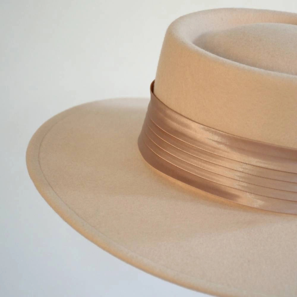 A close up back view of the beige beauty boater hat with the caramel satin hat band.