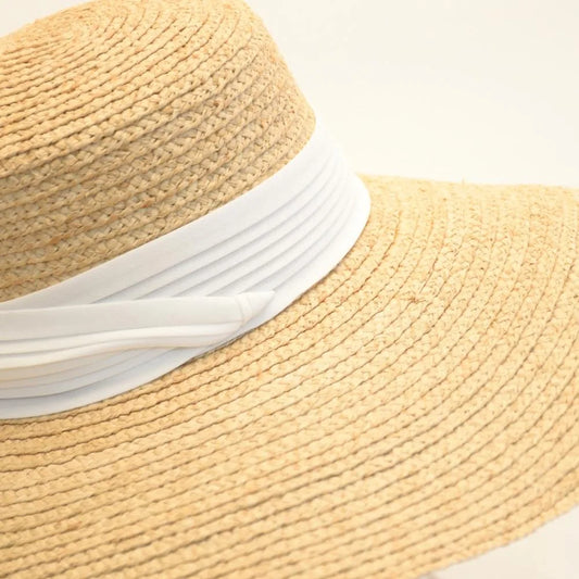 A close up of the pearl white hat band on the raffia straw satin lined hat.