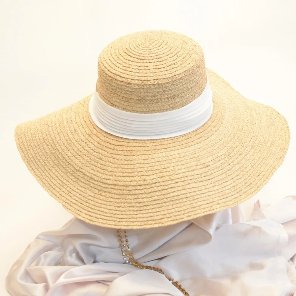 The front of the pearl white hat band on the raffia straw satin lined hat.