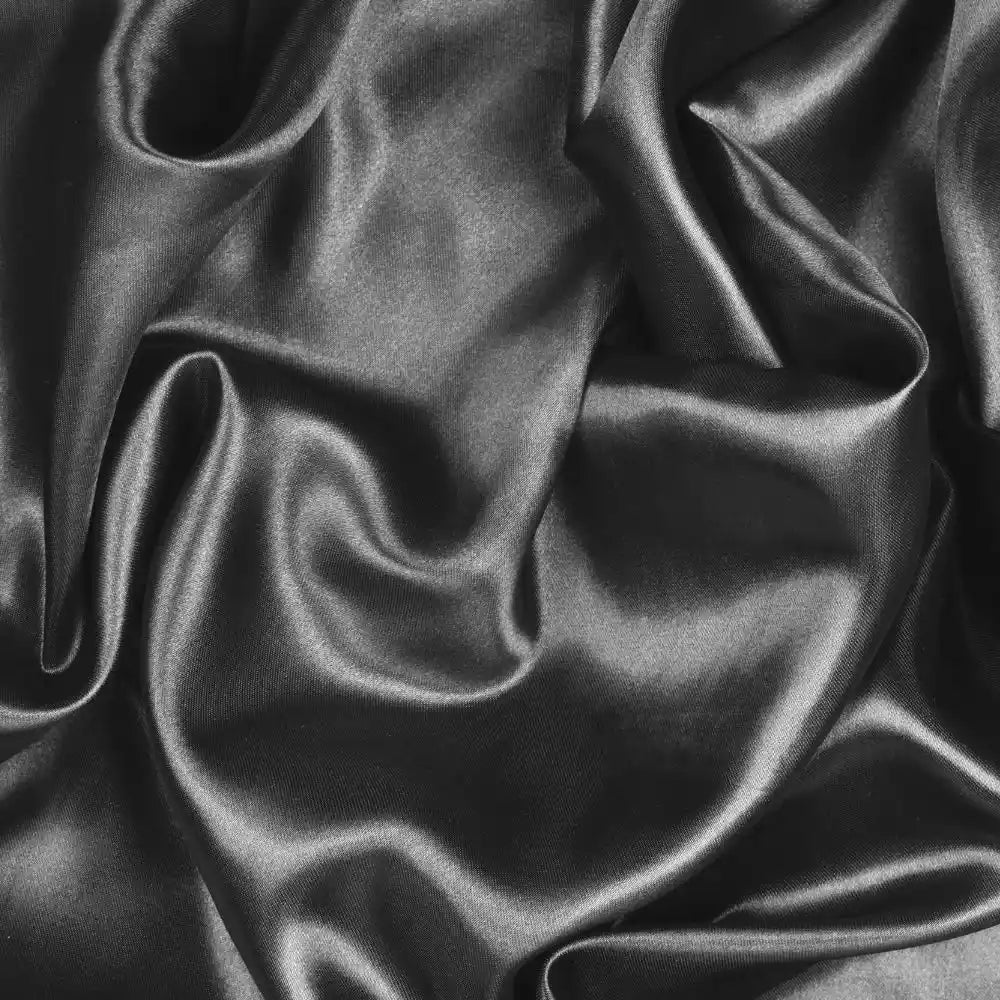 Black satin material scrunched up to show its folds.