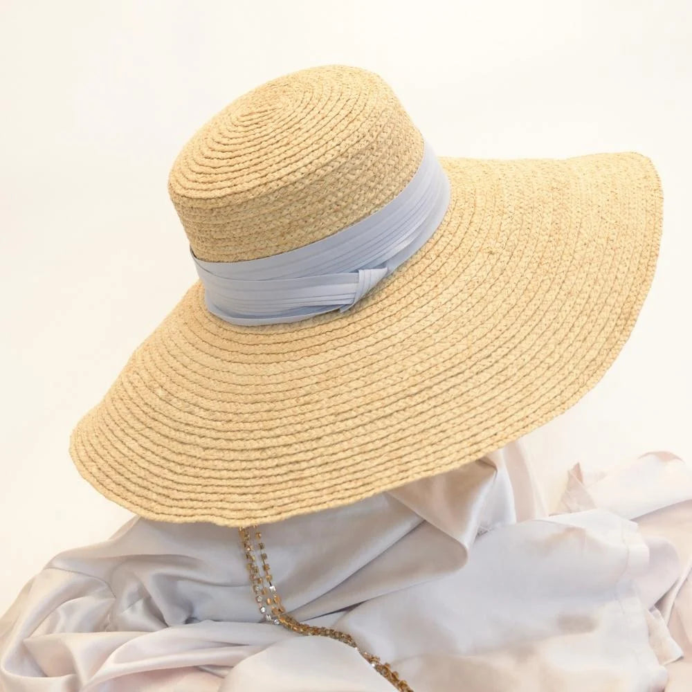 A full image of the Sunlit Dream Raffia Sun Hat with the Sky Blue hat band.