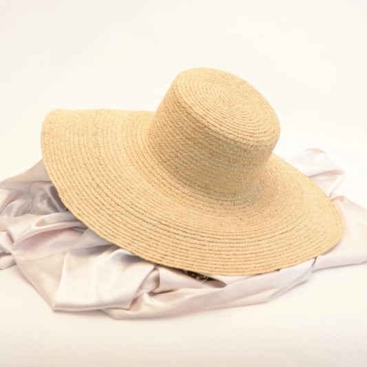 Sunlit dream satin lined raffia straw hat on a table.