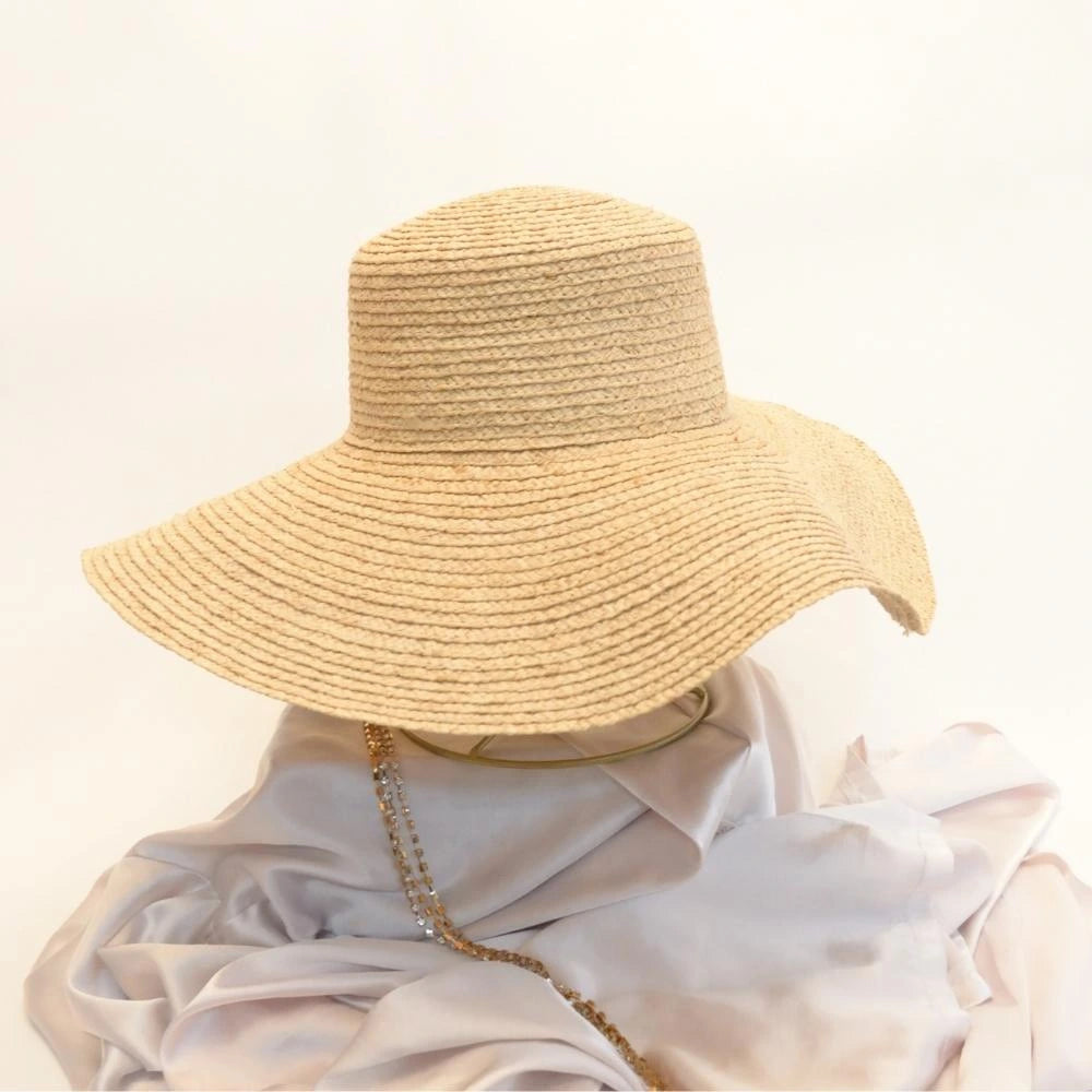 Side view of sunlit dream satin lined wide brimmed raffia sun beach hat.